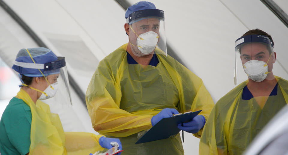 Medical personnel shown at a testing site in NSW as residents in multiple suburbs are urged to come forward. Source: AAP