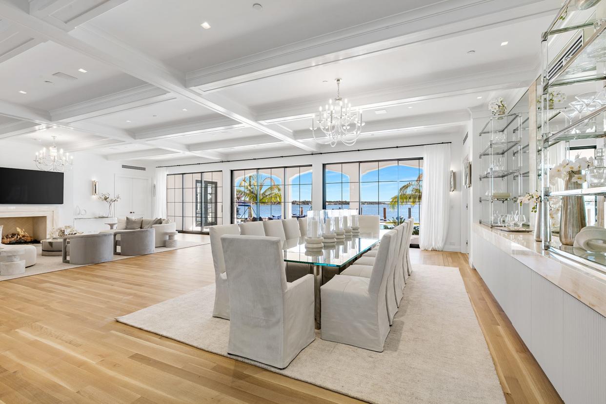The main living space at 10 Tarpon Island in Palm Beach has glass doors that open onto a loggia and poolside patio with dramatic water views.