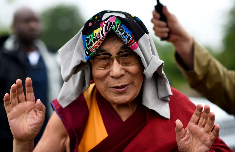 FILE PHOTO: The Dalai Lama greets well-wishers before addressing a crowd gathered at Worthy Farm in Somerset during the Glastonbury Festival