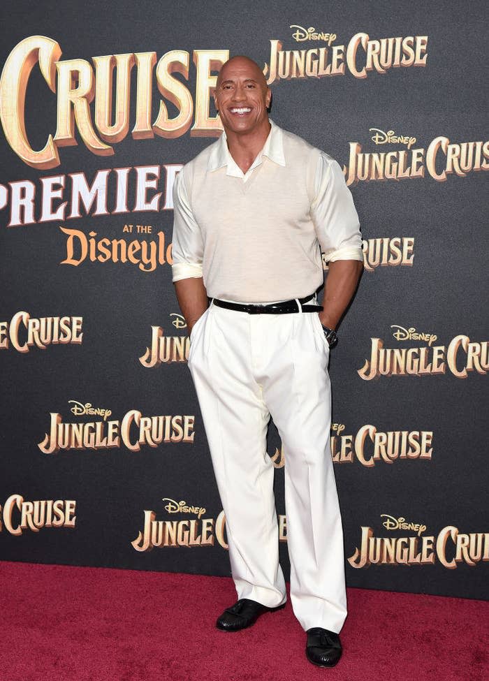 Dwayne Johnson attends the World Premiere of Disney's "Jungle Cruise" in a light-colored shirt and vest with matching pants