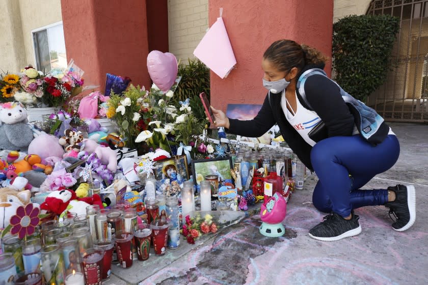 LOS ANGELES, CA - APRIL 16: Yajaira Para takes photos as she visits a growing memorial at Royal Villa Apartments at 8040 Reseda Blvd in Reseda Friday morning after the mother of three children found dead at their Reseda apartment admitted Thursday in a TV interview to killing the kids. From inside a Kern County jail, Liliana Carrillo said that she killed her children in order to protect them from their father. Reseda on Friday, April 16, 2021 in Los Angeles, CA. (Al Seib / Los Angeles Times).