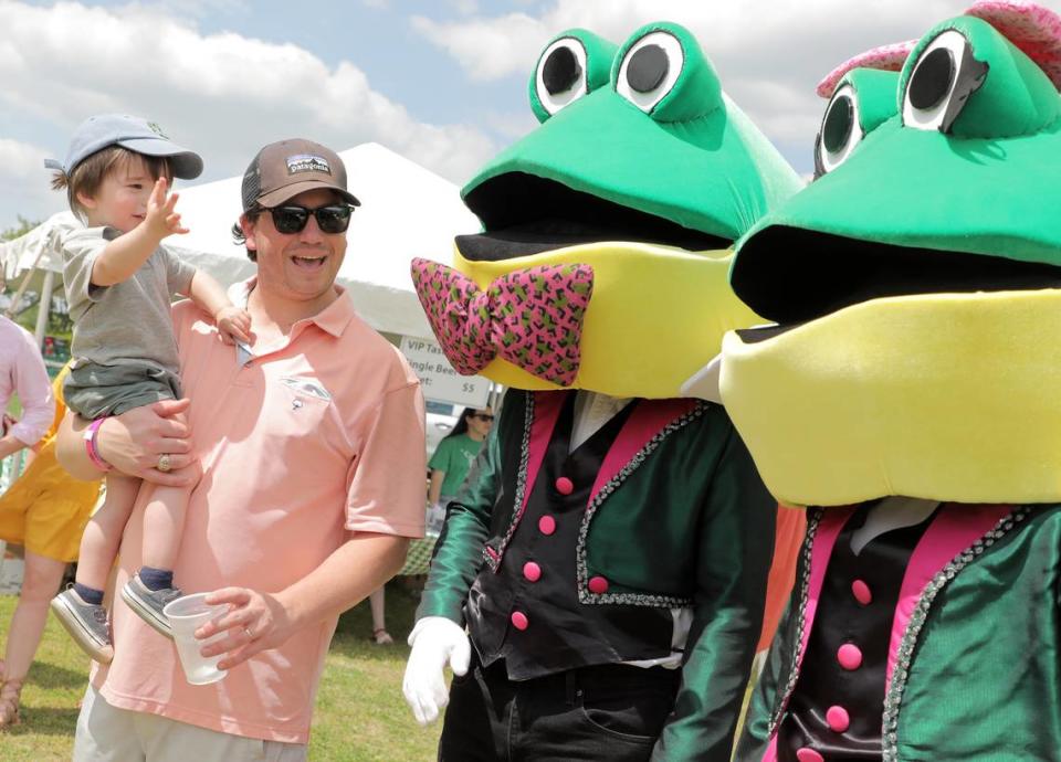 Cody Stegall and 1-year-old Henry Stegall say hello to Glen and Glenda the Frogs Saturday at the annual Come-See-Me Festival at Winthrop Lake.