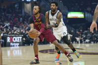 Cleveland Cavaliers' Darius Garland, left, drives against Brooklyn Nets' Kyrie Irving (11) in the first half of an NBA basketball game, Monday, Jan. 17, 2022, in Cleveland. (AP Photo/Tony Dejak)