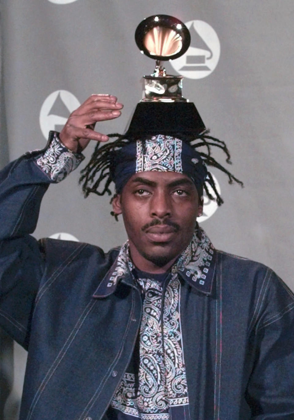 FILE - Coolio balances the Grammy he won for Best Rap Solo Performance at the 38th annual Grammy Awards at the Shrine Auditorium in Los Angeles, Wednesday, Feb.  28, 1996. Coolio, the rapper who was among hip-hop's biggest names of the 1990s with hits including “Gangsta’s Paradise”  and “Fantastic Voyage,”  has died.  Manager Jarez Posey tells The Associated Press that Coolio, whose legal name was Artis Leon Ivey Jr., died at the Los Angeles home of a friend on Wednesday, Sept.  28, 2022. He was 59. (AP Photo/Reed Saxon, File)