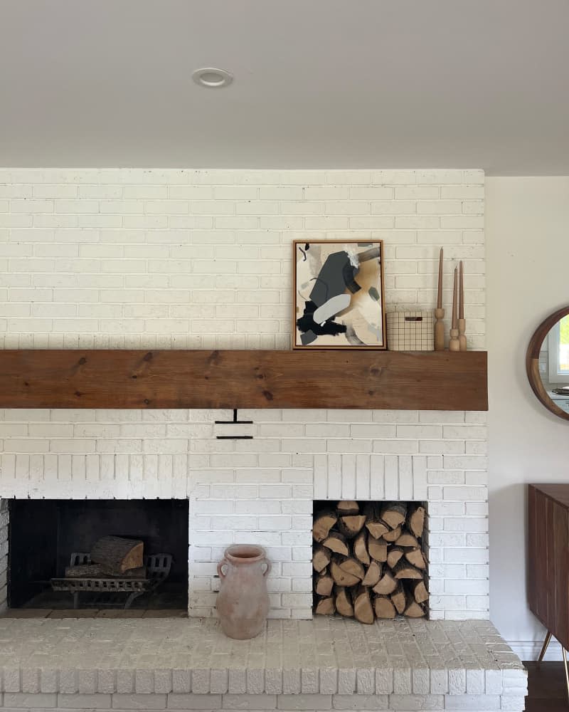 Wood stacked in a white painted fireplace.