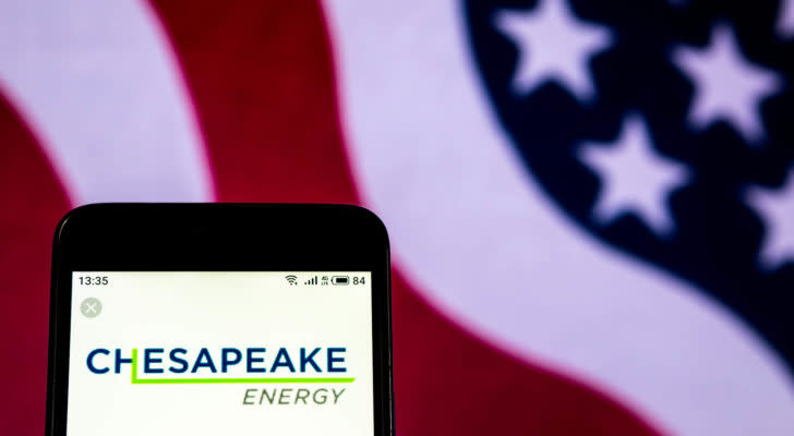 Chesapeake Energy (CHK) logo displayed on phone with American flag in background