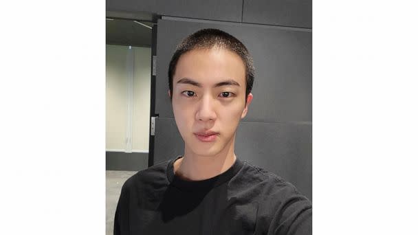 In this photo provided by Weverse, Jin of K-pop band BTS shows off freshly shaved hair on the K-pop social media platform Weverse, which was uploaded Sunday, Dec. 11, 2022, ahead of his upcoming military conscription. Jin, the oldest member of K-pop  (The Associated Press)