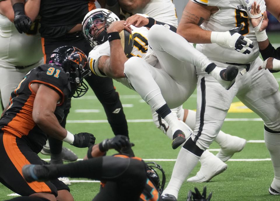 Tucson Sugar Skulls quarterback Ramone Atkins (10) is knocked into the air by the Arizona Rattlers at Footprint Center on April 8, 2023.