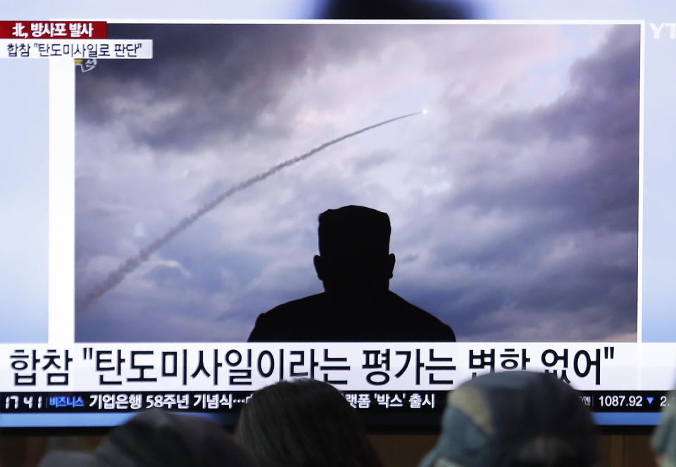 People watch a TV showing an image of North Korea's a multiple rocket launch during a news program at the Seoul Railway Station in Seoul, South Korea, Thursday, Aug. 1, 2019. North Korea said Thursday leader Kim Jong Un supervised the first test firing of a new multiple rocket launcher system that could potentially enhance its ability to strike targets in South Korea and U.S. military bases there. The signs read: "Ballistic missiles." (AP Photo/Ahn Young-joon)