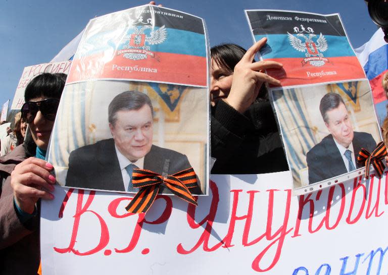 Pro-Russian protesters hold portraits of Ukraine's ousted leader Viktor Yanukovych during a rally in the eastern city of Donetsk, on March 22, 2014