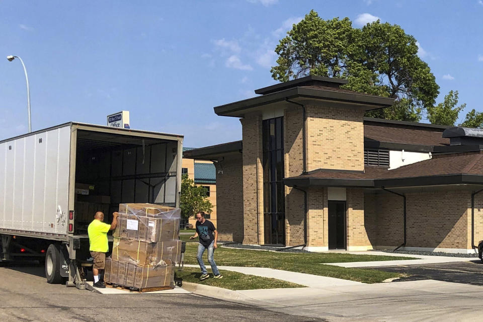 FILE - Moving company workers unload boxes for the Red River Women's Clinic that is setting up in a commercial building in Moorhead, Minn., on Aug. 5, 2022. A North Dakota judge on Monday, Oct. 31, 2022, affirmed his refusal to let the state’s abortion ban take effect despite the state Supreme Court ordering him to reconsider whether he had made the “appropriate” decision as a lawsuit over the law is pending. (AP Photo/Dave Kolpack, File)