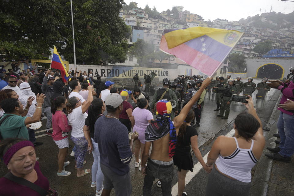 Los residentes se enfrentan a la Guardia Nacional mientras bloquean una calle para protestar por los resultados oficiales el día después de las elecciones presidenciales en Caracas, Venezuela, el lunes 29 de julio de 2024. (AP Foto/Fernando Vergara)