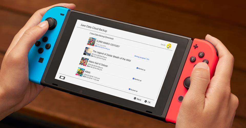 Close-up of a person's hands holding a Nintendo Switch game system.