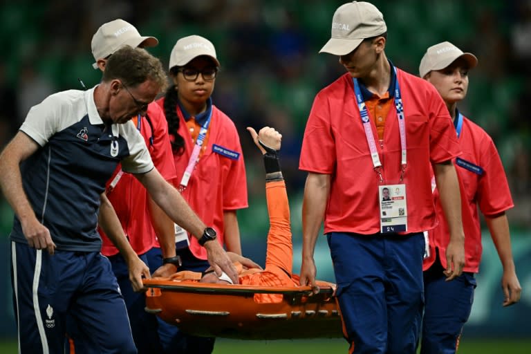 La arquera francesa Pauline Peyraud-Magnin levanta el pulgar mientras es evacuada en camilla del terreno de juego durante el partido del grupo A Francia-Canadá de los Juegos Olímpicos 2024, en el estadio Geoffroy-Guichard de Saint-Etienne, el 28 de julio de 2024 (Arnaud FINISTRE)