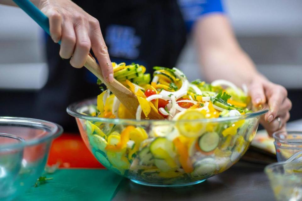 Woodford County Family & Consumer Sciences Extension Agent Elizabeth Coots prepares a garden patch salad, a mix of sliced summer vegetables tossed with a vinegar dressing July 7, 2021 in Versailles. Coots was making the dish as part of a livestream, preparing recipes from the University of Kentucky Cooperative Extension Service’s food and nutrition calendar.