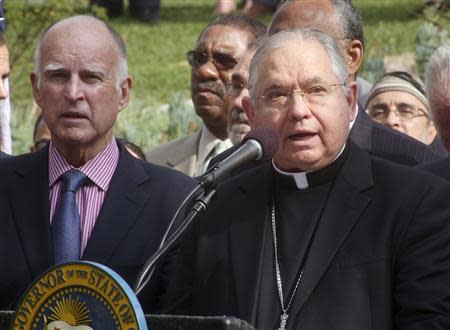 California Governor Jerry Brown (L) listens to Los Angeles Catholic Archbishop Jose Gomez during ceremonies before Brown signed AB60 into law in Los Angeles October 3, 2013. REUTERS/Fred Prouser