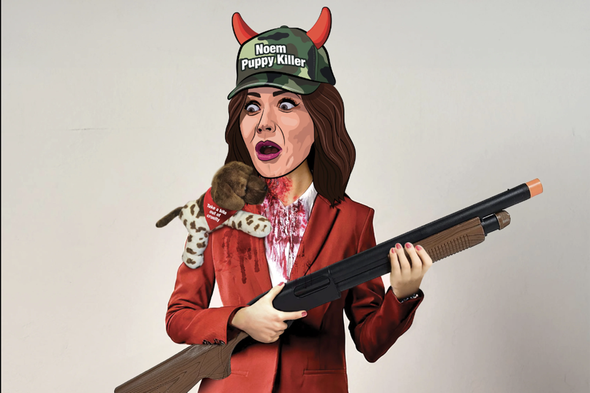 The costume features a mask of Ms Noem’s face with devil horns and a camo hat imprinted with ‘Noem: Puppy Killer,’ and a fake gun (PETA)