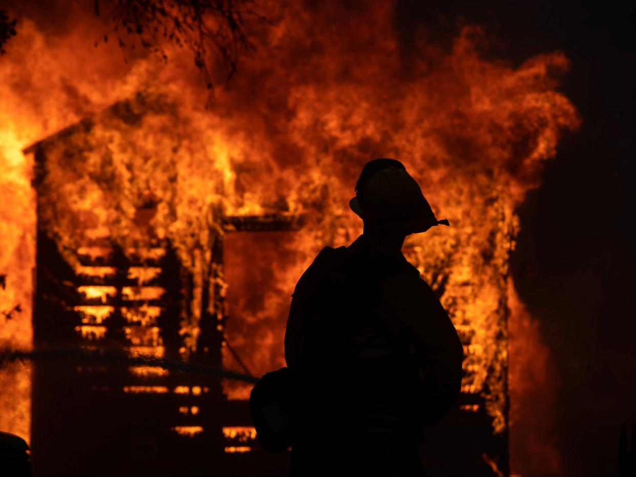 A firefighter looks on at the Zogg WildFire near Igo, California (Adam Gray/SWNS )