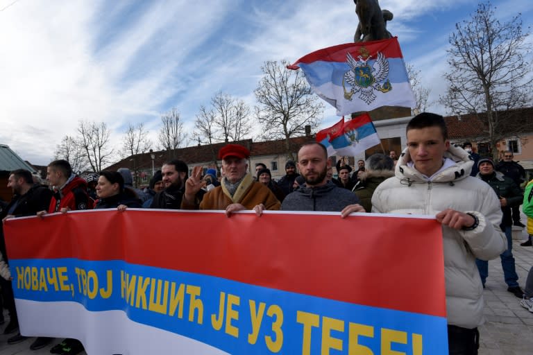 Unos manifestantes sostienen una bandera serbia durante una protesta contra el gobierno de Australia y en apoyo a Novak Djokovic, el 7 de enero de 2022 en Niksic (Montenegro). La leyenda dice "Novan, tu ciudad de Niksic está contigo" (AFP/Savo Prelevic)