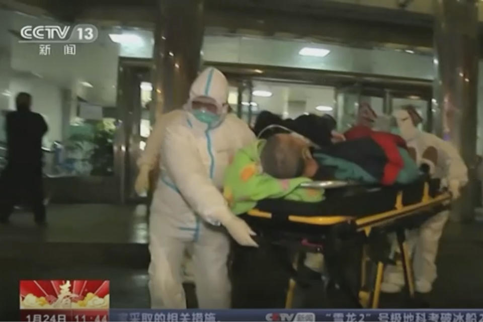 In this Thursday, Jan. 23, 2020, image from China's CCTV video, a patient is carried on a stretcher to an ambulance by medical workers in protective suits in Wuhan, China. China is swiftly building a hospital dedicated to treating patients infected with a new virus that sickened hundreds and prompted unprecedented lockdowns of cities home to millions of people during the country's most important holiday. (CCTV via AP)