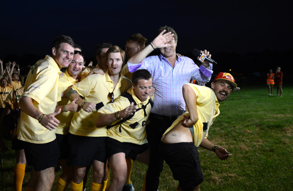 Australian television host Richard Wilkins is mooned by a fan as over 1000 Australian fans spell out the word G'Day on Clapham Common in London, Wednesday, July 25, 2012. The fans attempted to break the Guinness World record for The Most People Wearing The Same Full Team Kit.