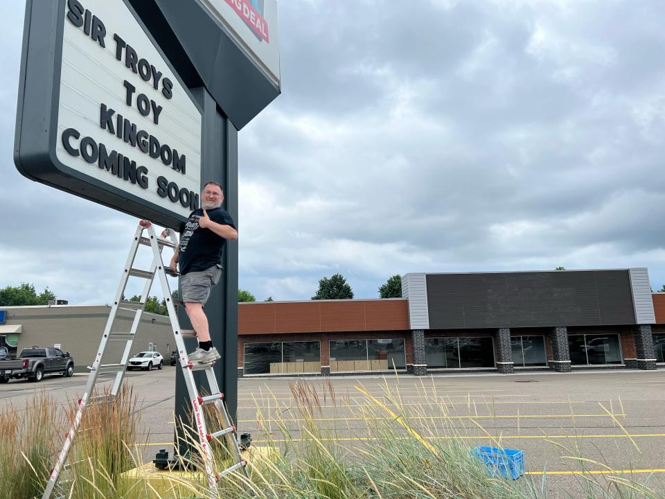 Troy Cefaratti, owner of Sir Troy's Toy Kingdom, posts a sign at the Belden Square Plaza announcing plans to open there. (Submitted photo)
