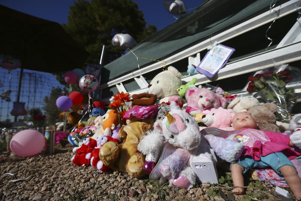 A makeshift memorial grows in front of the home where Rachel Henry was arrested on suspicion of killing her three children after they were found dead inside the family home earlier in the week, shown here Thursday, Jan. 23, 2020, in Phoenix. (AP Photo/Ross D. Franklin)