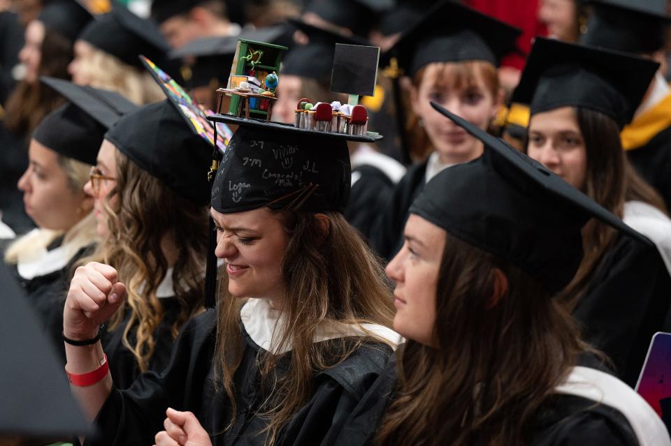 Hope Briden, a master's of English recipient, celebrates while wearing a three-dimensional classroom on her cap during Clark University's 2023 commencement ceremony Sunday.