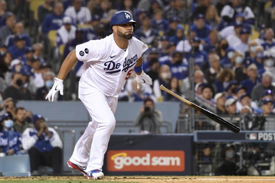 Dodgers' Albert Pujols tosses his bat after hitting a single.