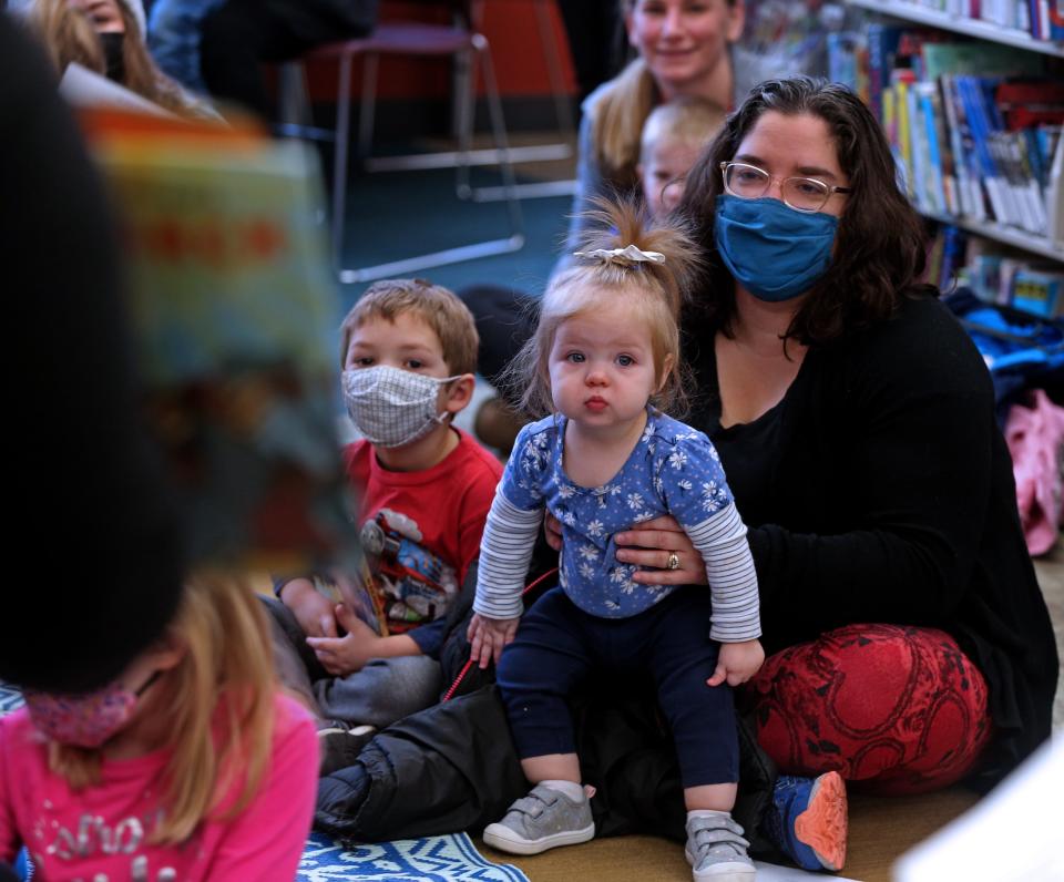 Emily Hare and her children, Kaden, 3, left and Emma, 1, center,  listens to stories about civil rights leader Martin Luther King, Jr., during a story time that celebrated the legacy of King at the Waukesha Public Library at 321 Wisconsin Ave.on Monday, Jan. 17, 2022. The public was also invited to contribute to a collaborative art journal to share their thoughts and feelings about the holiday and other social issues.