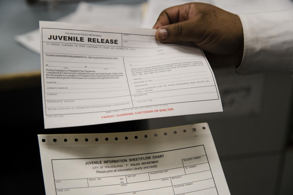 In this Friday, Oct. 26, 2018, photo, Philadelphia Police Sgt. John Ross displays forms regarding juveniles at the Police 9th District in Philadelphia. Bloomberg Philanthropies announced the winners Monday of the U.S. Mayors Challenge that asked cities to develop innovative solutions to their biggest problems that other cities could copy. Philadelphia plans to build a juvenile justice hub designed to make contact with police less traumatic, keep more children out of the criminal justice system and connect at-risk juveniles with intervention services at a crisis point that could change their lives. (AP Photo/Matt Rourke)