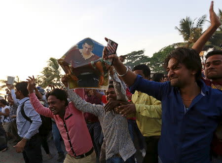 Fans of Bollywood actor Salman Khan hold his portrait as they celebrate outside his house in Mumbai, December 10, 2015. REUTERS/Danish Siddiqui