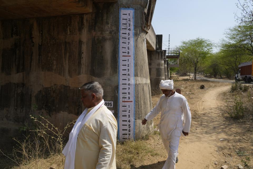 Villagers walk in the dry bed of the Shahibi River near Bawal, in the Indian state of Haryana, Thursday, March 7, 2024. (AP Photo/Manish Swarup)