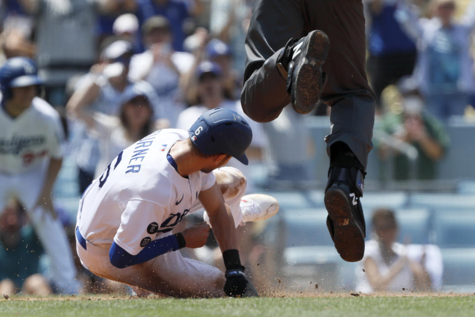 Home plate umpire John Tumpane, right, leaps away from Los Angeles Dodgers' Trea Turner, left, who was sliding into home on a single by AJ Pollock during the second inning of a baseball game against the Los Angeles Angels in Los Angeles, Sunday, Aug. 8, 2021. (AP Photo/Alex Gallardo)