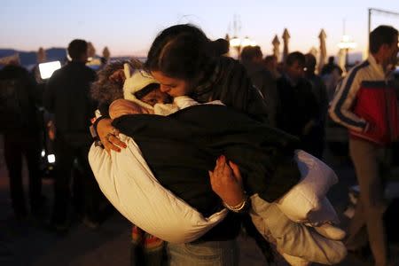 A volunteer carries a rescued migrant child after a boat carrying more than 200 refugees and migrants sunk while crossing part of the Aegean sea from Turkey, on the Greek island of Lesbos, October 28, 2015. REUTERS/Giorgos Moutafis