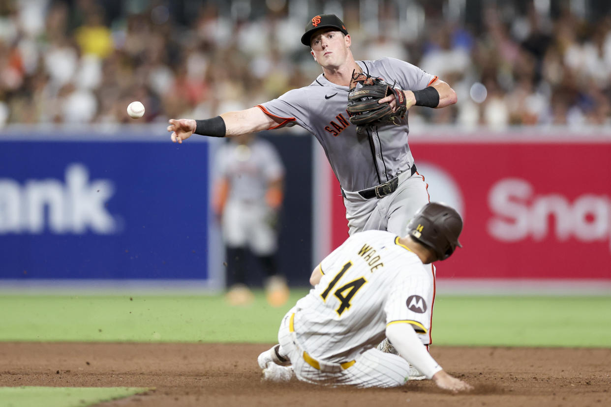 San Francisco Giants shortstop Tyler Fitzgerald, top, throws out San Diego Padres' Mason McCoy at first base to complete a double play after forcing out Tyler Wade, bottom, during the sixth inning of a baseball game Saturday, Sept. 7, 2024, in San Diego. (AP Photo/Ryan Sun)