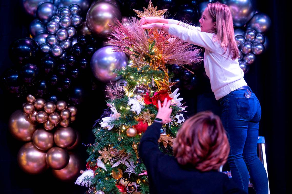 Tree decorator Tammy Hall directs Trixy Dorn of Tacoma on the positioning of ornaments atop their tree named “Starry Night” during decorating day at the Mary Bridge Children’s Festival of Trees on Tuesday, Nov. 29, 2022, at the Tacoma Armory in Tacoma. Pete Caster/Pete Caster / The News Tribune