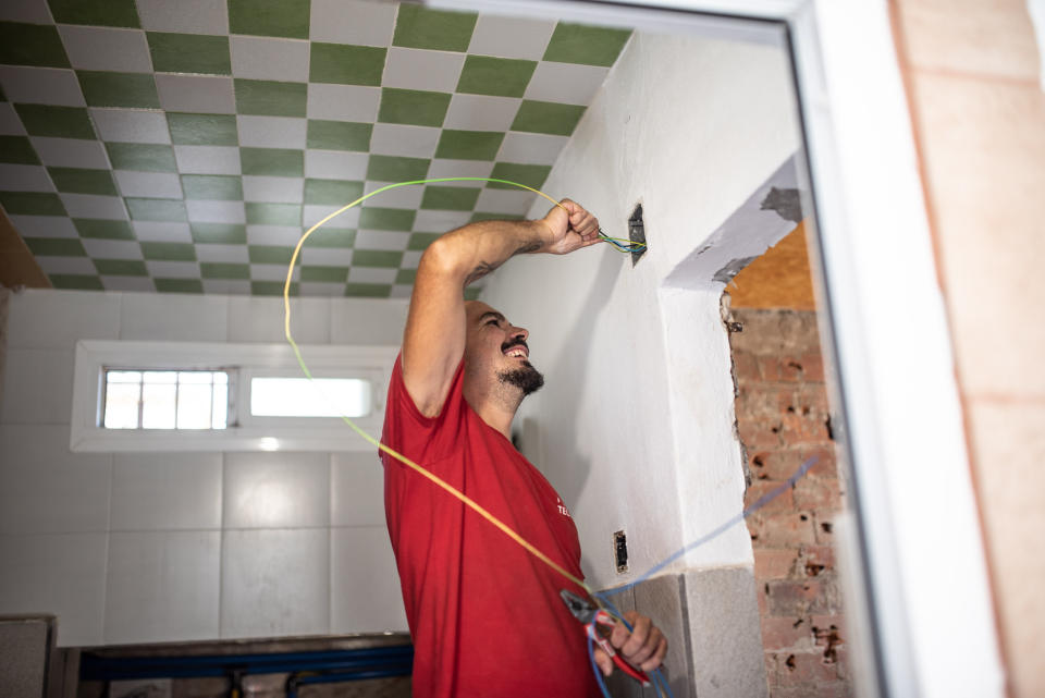 A man putting a wire into the wall