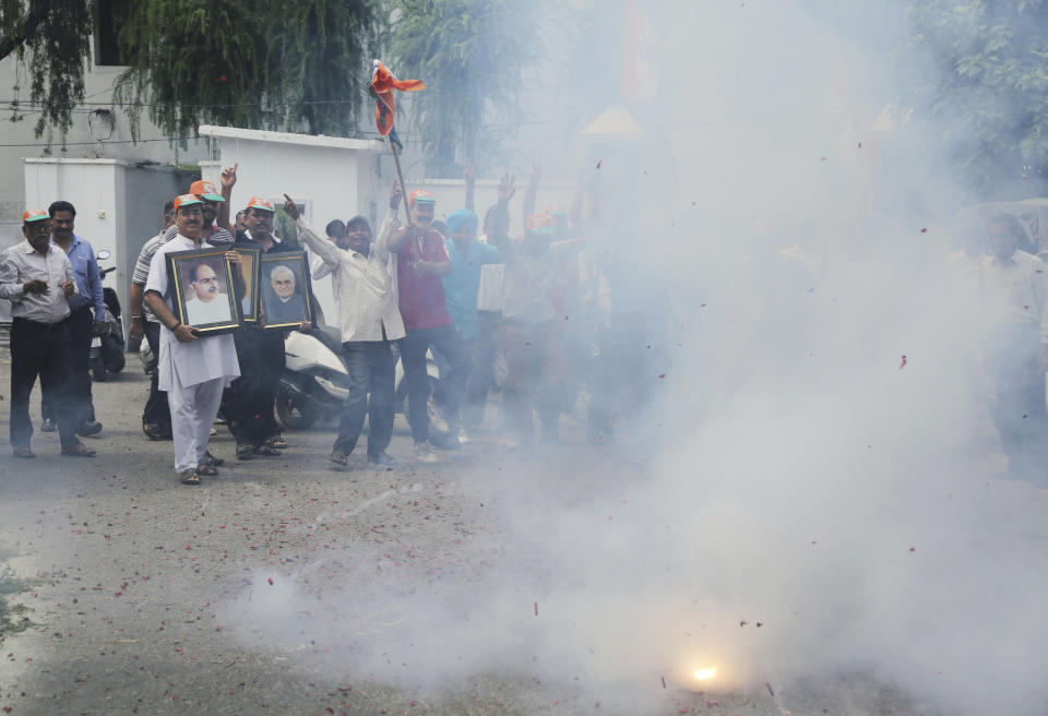 Supporters of India's ruling Bharatiya Janata Party (BJP) light fire crackers as they celebrate the government revoking Kashmir's special status in Jammu, India, Tuesday, Aug.6, 2019. India's lower house of Parliament was set to ratify a bill Tuesday that would downgrade the governance of India-administered, Muslim-majority Kashmir amid an indefinite security lockdown in the disputed Himalayan region. The Hindu nationalist-led government of Prime Minister Narendra Modi moved the "Jammu and Kashmir Reorganization Bill" for a vote by the Lok Sahba a day after the measure was introduced alongside a presidential order dissolving a constitutional provision that gave Kashmiris exclusive, hereditary rights. (AP Photo/Channi Anand)