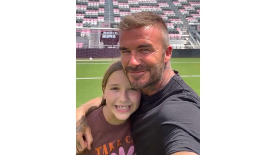 father and daughter on football pitch 