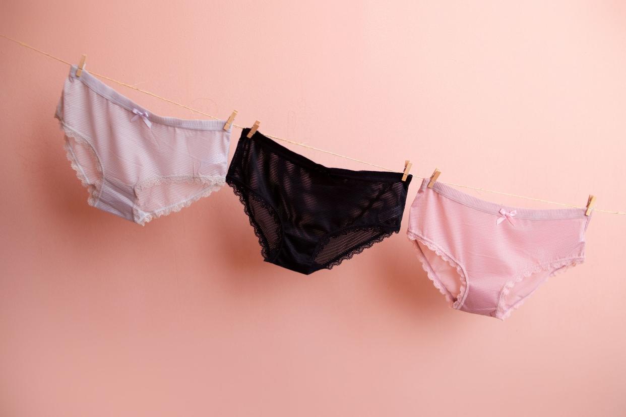 colorful clean women's panties hang on a rope. on a pink isolated background.