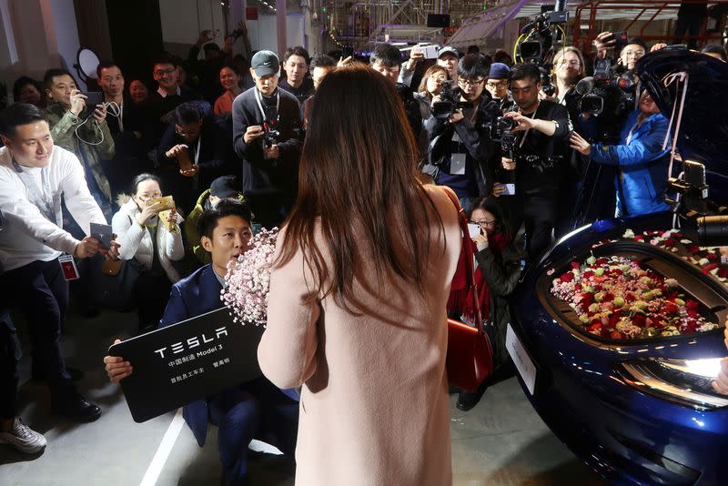 Tesla employee proposes to his girlfriend with a China-made Tesla Model 3 vehicle filled with flowers at a delivery ceremony in the Shanghai Gigafactory of the U.S. electric car maker in Shanghai