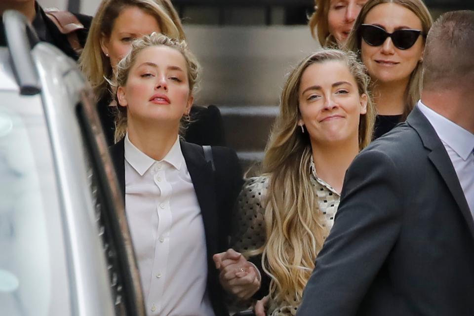 TOPSHOT - US actress Amber Heard (L) leaves hand-in-hand with her sister Whitney Heard (R) from the High Court after a hearing in the libel trial by her former husband US actor Johnny Depp against News Group Newspapers (NGN) in London, on July 24, 2020. - Depp is suing the publishers of The Sun and the author of the article for the claims that called him a "wife-beater" in April 2018. (Photo by Tolga AKMEN / AFP) (Photo by TOLGA AKMEN/AFP via Getty Images)