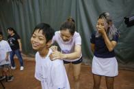 Two-time Grand Slam champion Li Na signs a tee-shirt for one of the students attending the clinic she led at the Sutton East Tennis Club Thursday, July 18, 2019, in New York. Li Na will be inducted into the Tennis Hall of Fame on Saturday, July 20. (AP Photo/Kevin Hagen)