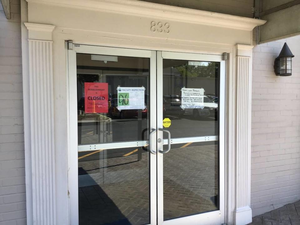 Signs on the door at Puccini’s Pizza Pasta in Chevy Chase Place on May 5, 2023, include a health department closure notice, an inspection score and a note from management saying the restaurant is closed for plumbing repairs.