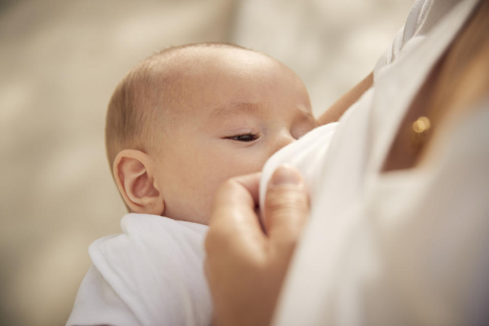 A woman breast feeding a baby.