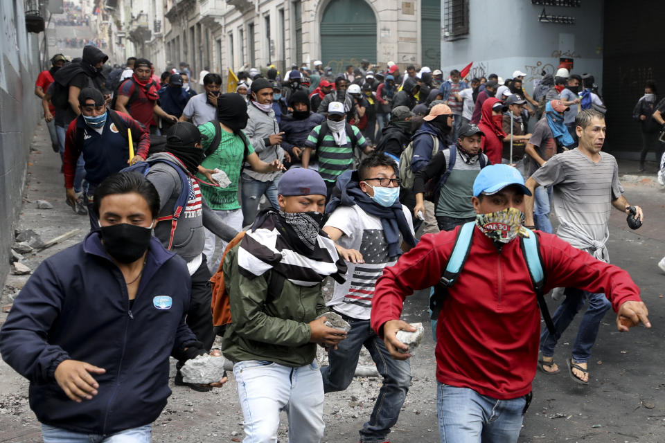 Anti-government protesters, stones in hand, run during clashes in downtown Quito, Ecuador, Oct. 8, 2019. (Photo: Fernando Vergara/AP)