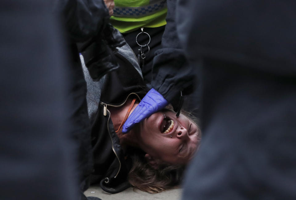Riot police arrests a protester who shouted 'I can't breathe' after taking part in a 'We Do Not Consent' rally at Trafalgar Square, organised by Stop New Normal, to protest against coronavirus restrictions, in London, Saturday, Sept. 26, 2020. (AP Photo/Frank Augstein)