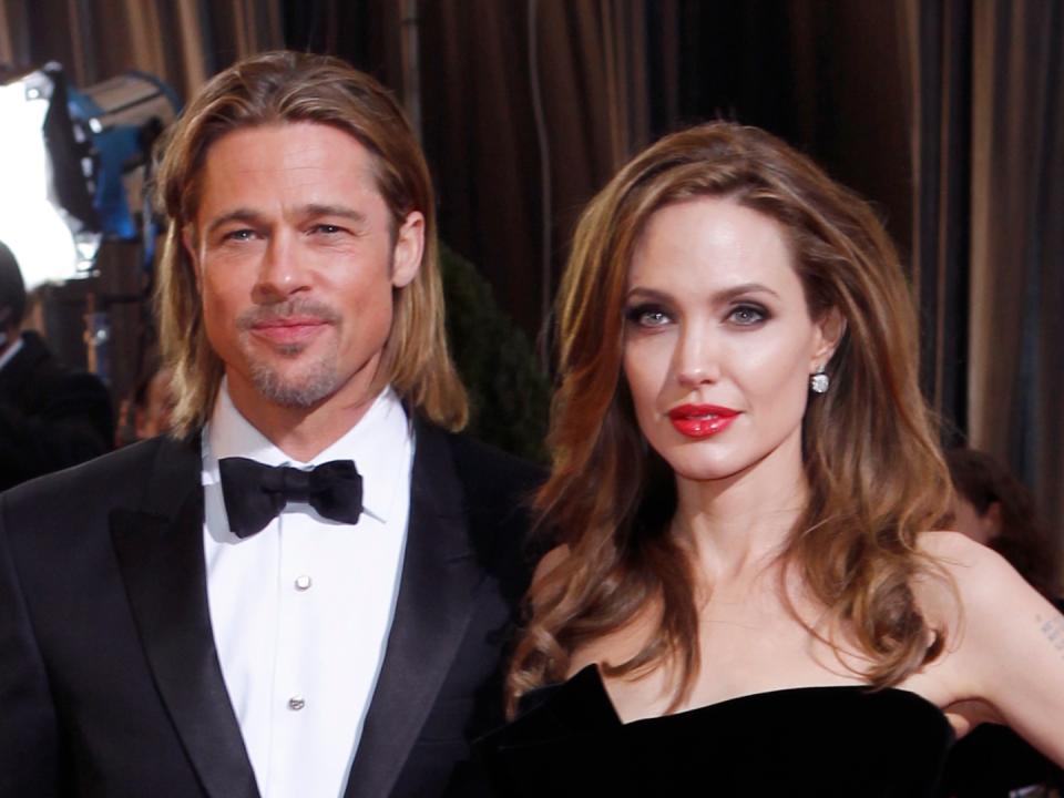 Brad Pitt (L) and Angelina Jolie attend the 84th annual Academy Awards at the Hollywood & Highland Center. Jolie wears Atelier Versace with Neil Lane jewelry, a Jaime Mascaro clutch and Salvatore Ferragamo shoes. 