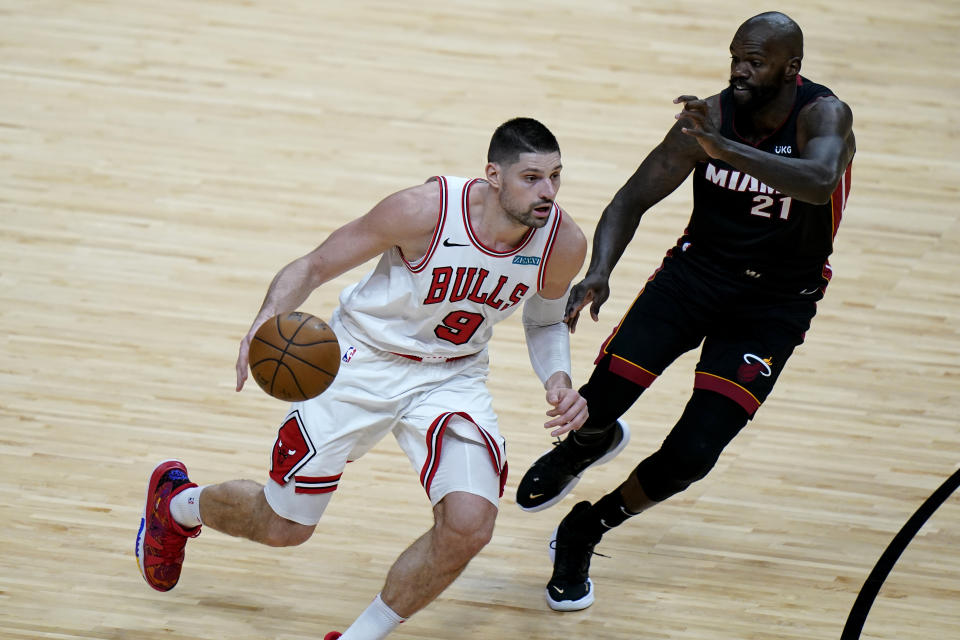 Chicago Bulls center Nikola Vucevic (9) drives to the basket as Miami Heat center Dewayne Dedmon (21) defends during the second half of an NBA basketball game, Monday, April 26, 2021, in Miami. (AP Photo/Lynne Sladky)